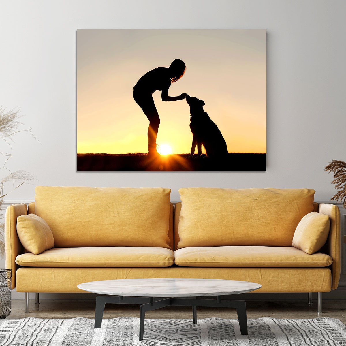 A silhouette of a girl sitting outside in the grass with her pet German Shepherd Mix Dog feeding him treats during training in front of a sunsetting sky. Canvas Print or Poster