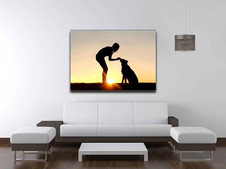 A silhouette of a girl sitting outside in the grass with her pet German Shepherd Mix Dog feeding him treats during training in front of a sunsetting sky. Canvas Print or Poster - Canvas Art Rocks - 4